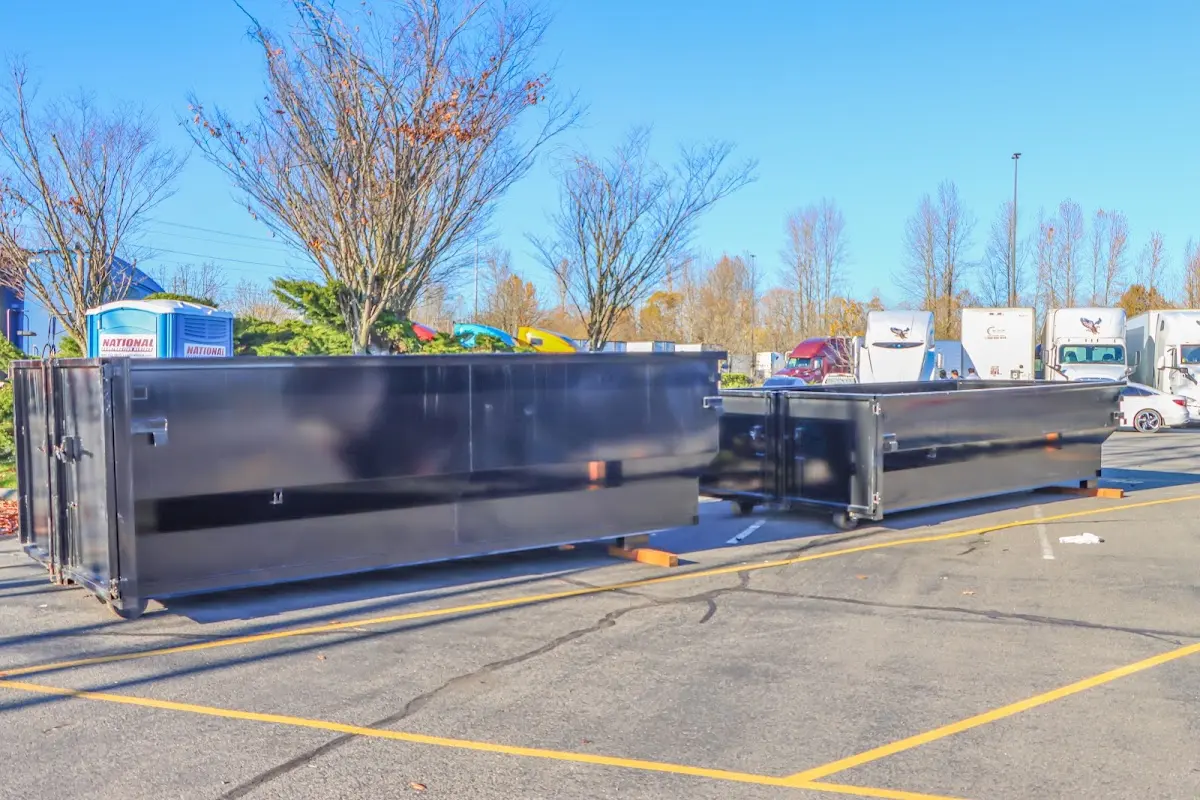 Professional dumpster rental service with roll-off container on residential driveway in Bend